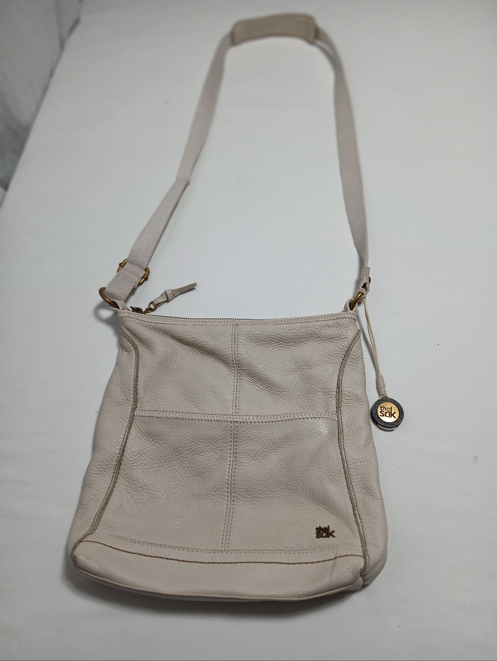 The Sak Cream Leather Crossbody Bag with Gold Charm